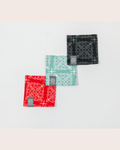 Three Sabah patterned coaster in red, light mint green, and black on a light gray background